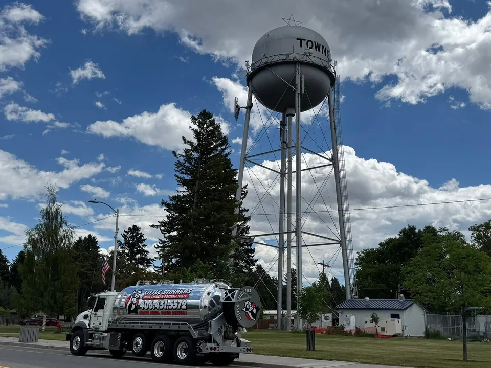 Little Stinkers septic service truck beneath the Townsend water tower